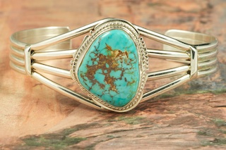 Genuine Royston Turquoise set in Sterling Silver Bracelet. The Royston Turquoise Mine was originally known as the Royal Blue Mine. It produces Turquoise that has a mixture of blues and greens in the same formation. The Royston Turquoise Mine is located in Nye County, Nevada. Created by Navajo Artist Kathy Yazzie. Signed by the artist.